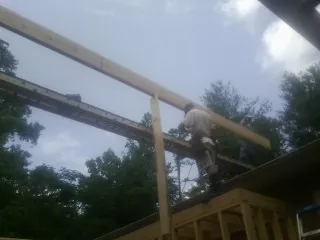 Carpenter setting a ridge beam over a new addition frame — Ice Dam Removal by Roofing Brothers in Califon