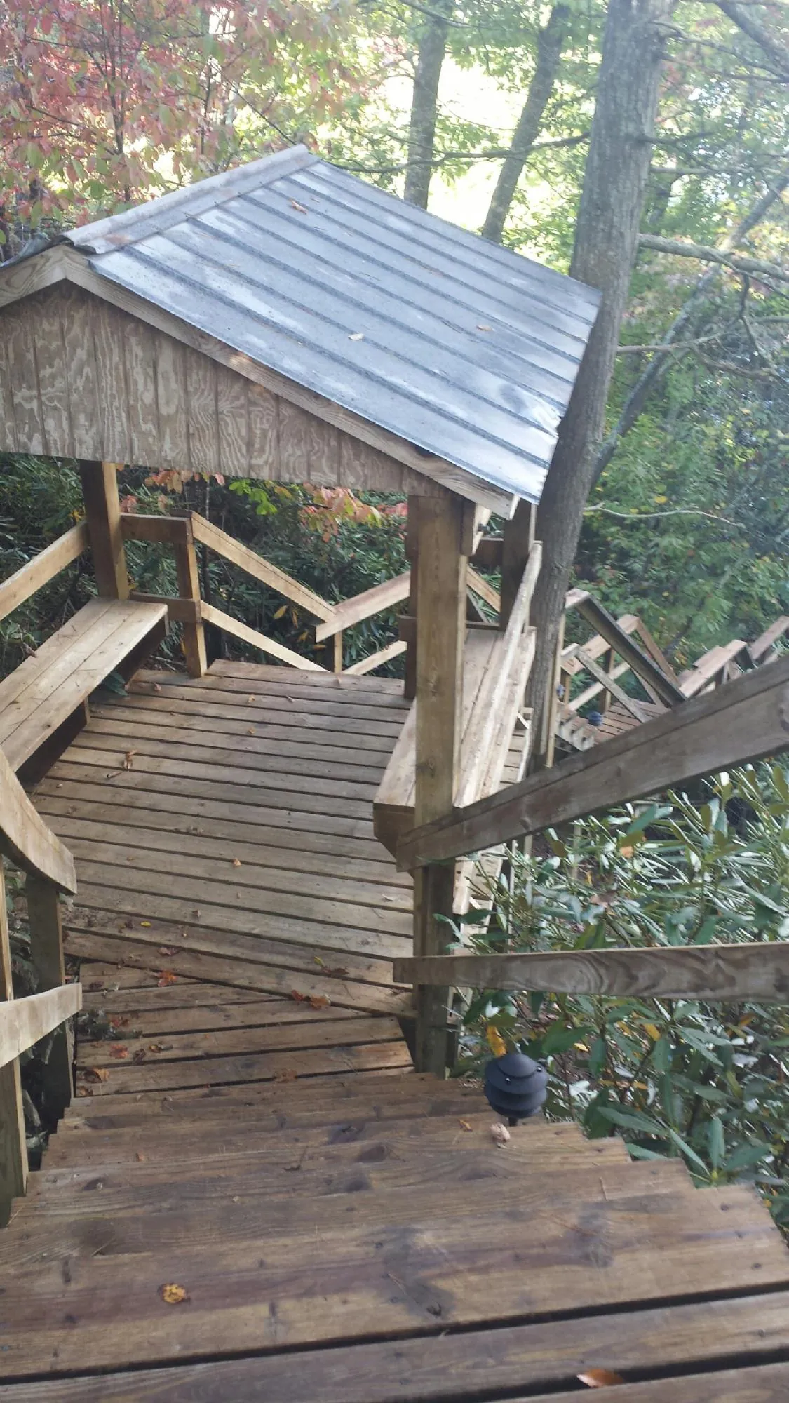 Metal roofed shelter over wooden steps on a wooded walkway — Skylight Repair & Installation work by our crew in Califon